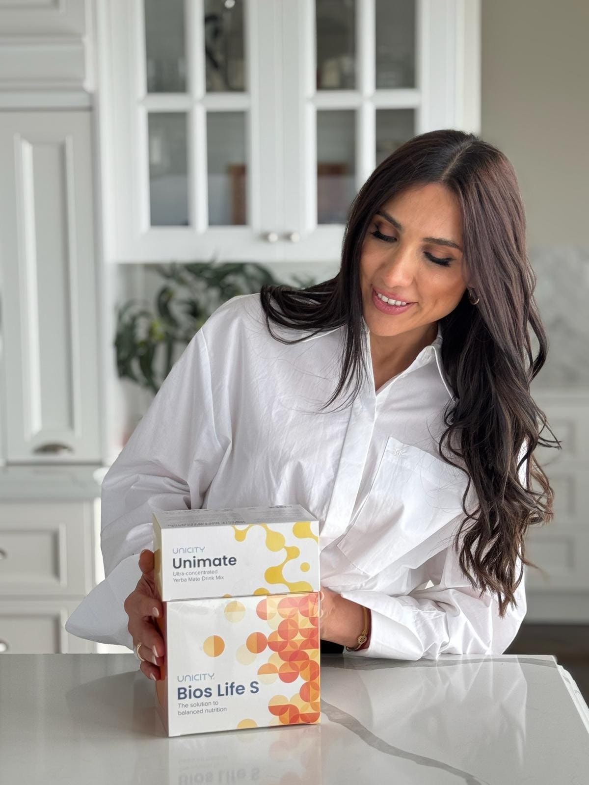 Mona Assaad holding Feel Great System products